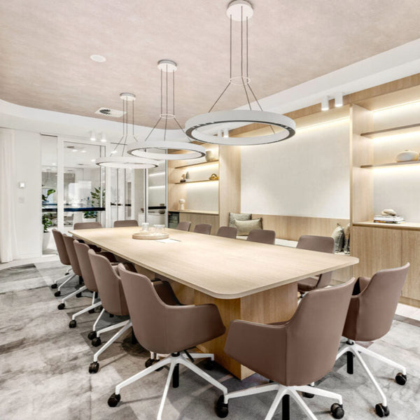 Modern office conference room with a long table and chairs. White halo pendant feature lighting