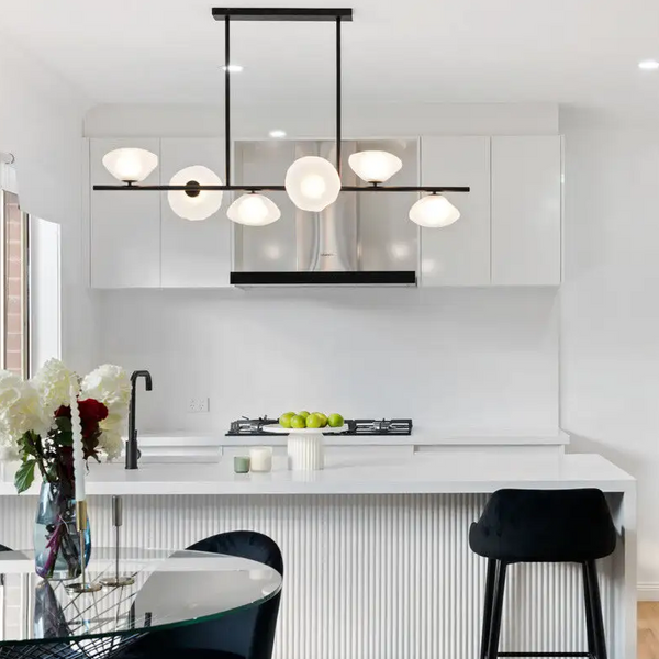 Modern kitchen with white countertops and black pendant light linear