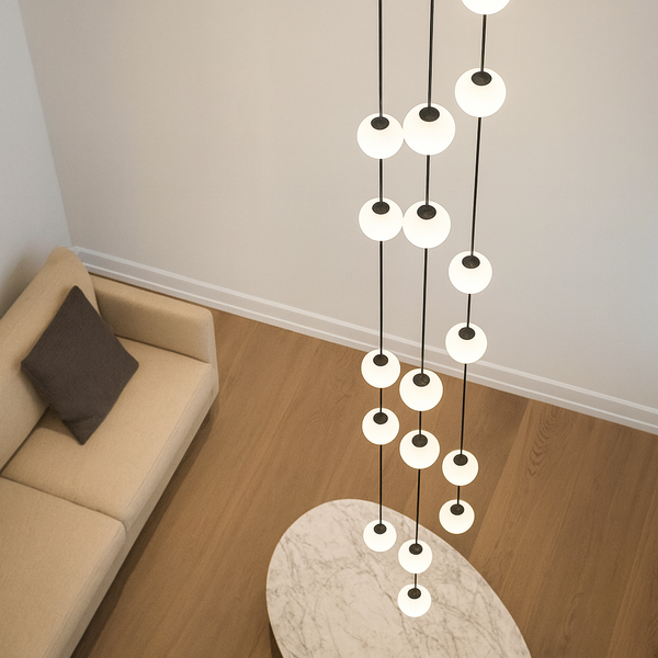Modern chandelier hanging in a living room with a beige sofa and wooden floor.