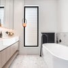 Modern bathroom with freestanding bathtub, vanity, and decorative elements.