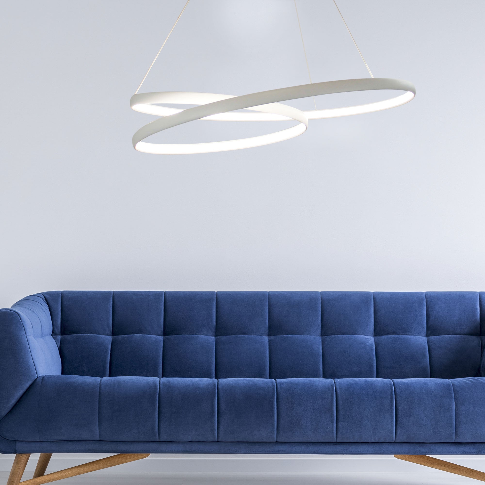 endless modern circular pendant in white over a blue sofa suspended loop lighting 2020 latest trends