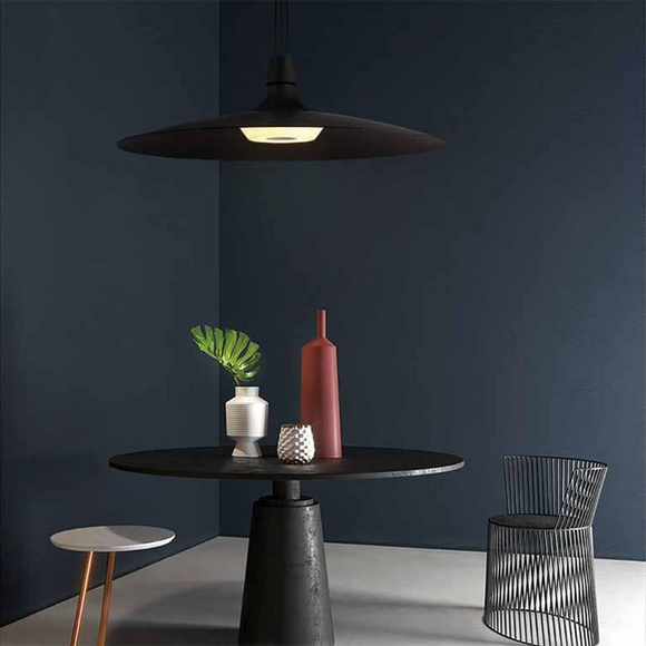 modern black and copper wide shade pendant mounted over a sleek circular dining table 